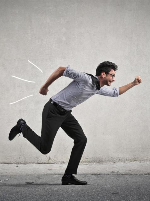 un homme en tenue de bureaucrate cours dans une rue