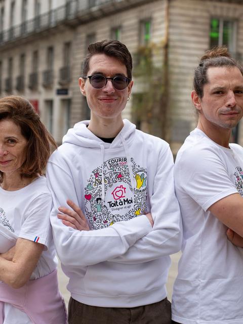 3 personnes regardent l'objectif avec un air de défi. Elles portent un t-shirt avec un visuel de la course de Toit à Moi